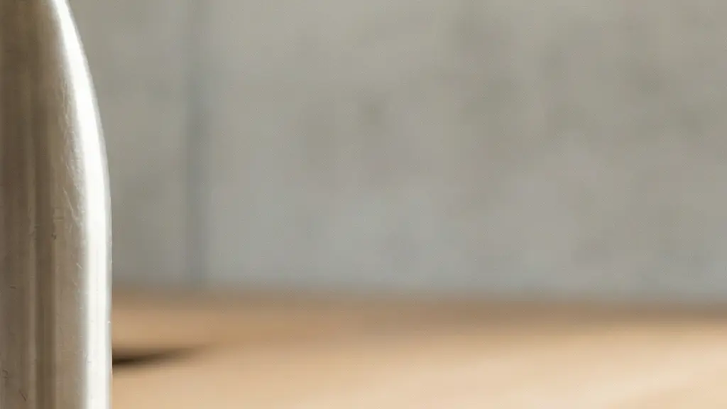 Bouteille isotherme en métal légèrement patinée posée sur un bureau minimaliste, suggérant un usage répété sur la durée.